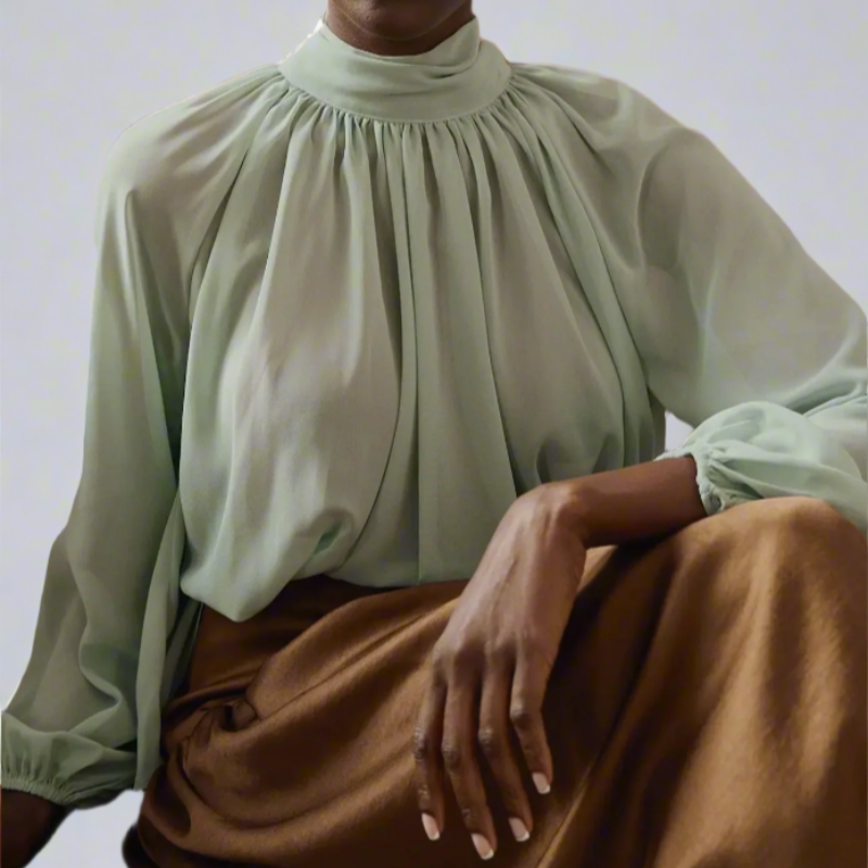 Soft, flowing Georgette fabric and delicate pleating with high neckline adds a touch of classic romance, while the billowy sleeves brings a little drama with subtle volume and texture