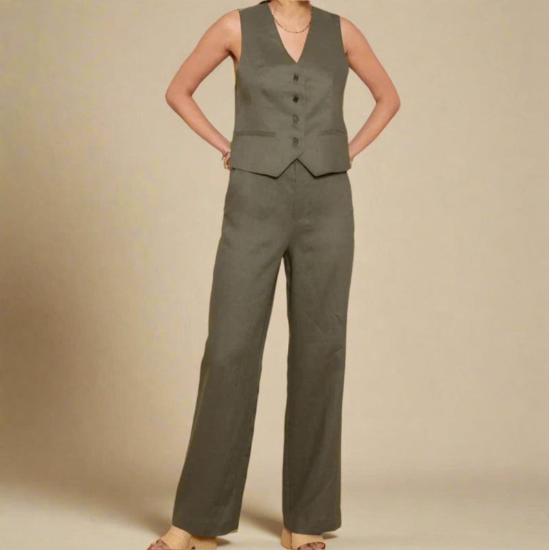 Woman wearing a green linen vest and pants set against a beige background