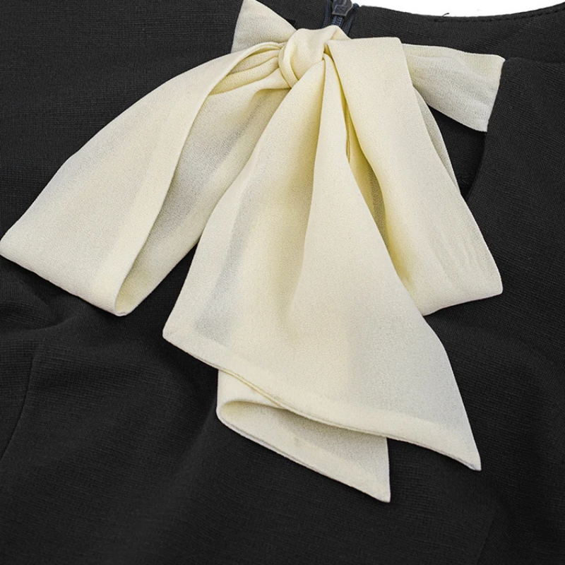 Elegant black office sheath dress with cream bow tie at the neck and matching flared sleeve cuffs, fitted silhouette for work or evening wear.