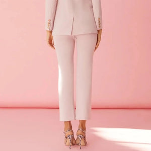 Skinny ankle straight-leg blush light pink trousers with Collarless blush blazer with gold medallion buttons. Chic and stylish blazer pant suit in classic cut