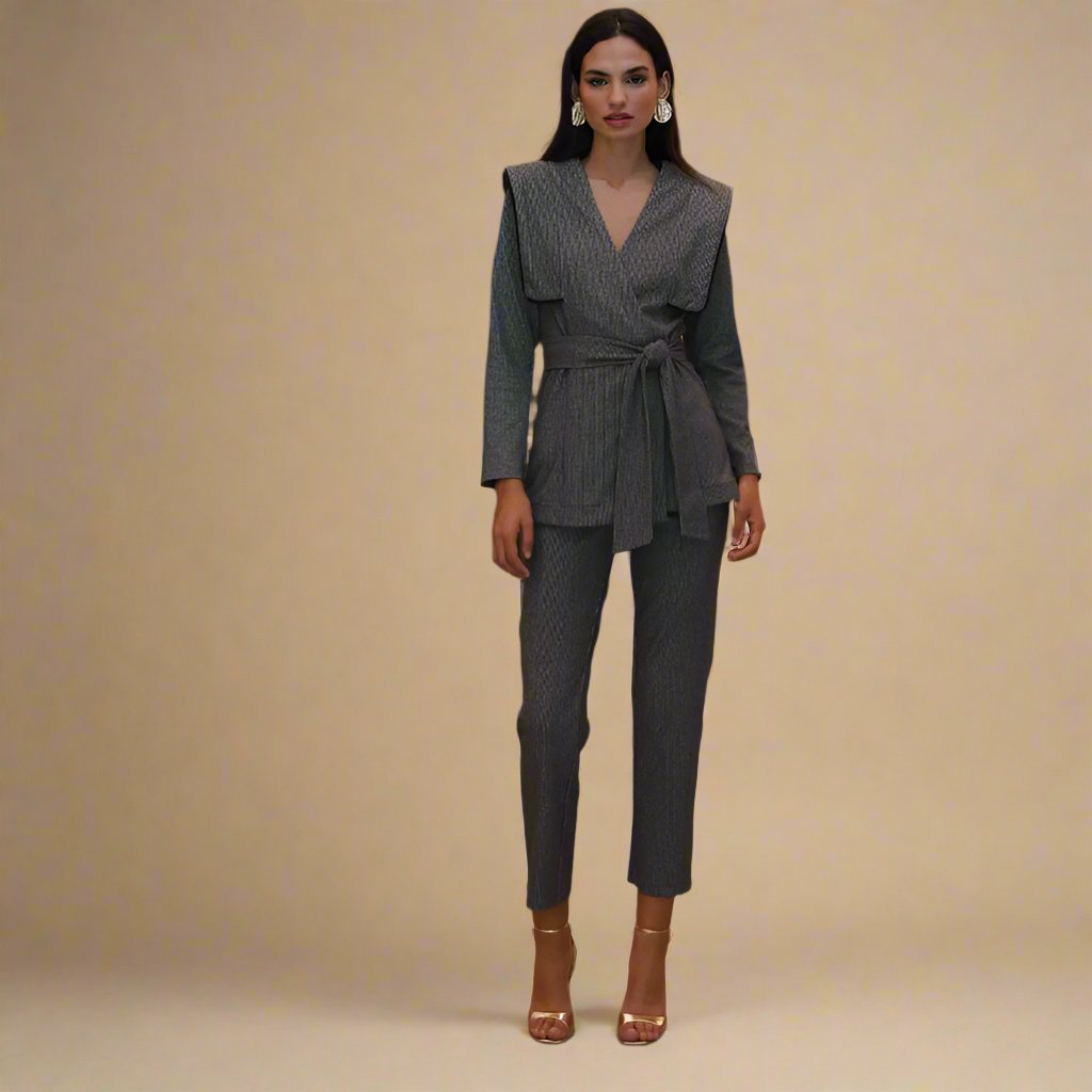 Classic charcoal suit in a unique exaggerated shoulder with belted tie blazer and cropped ankle length trouser. 