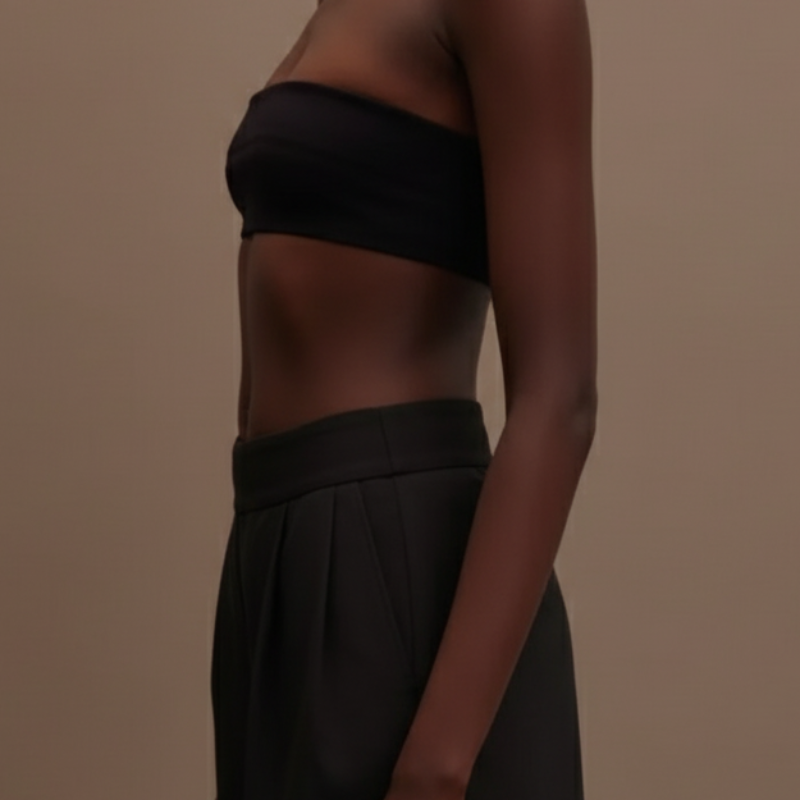 Person wearing a black strapless top against a plain background
