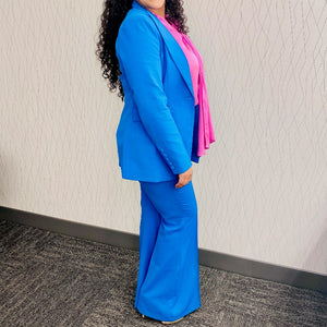 Bold and powerful woman's pant suit in bold bright azure blue, pink and yellow. Tailored cut flattering the curves while still being professional and conservative enough for any business meeting or the office.