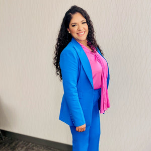 Bold and powerful woman's pant suit in bold bright azure blue, pink and yellow. Tailored cut flattering the curves while still being professional and conservative enough for any business meeting or the office.