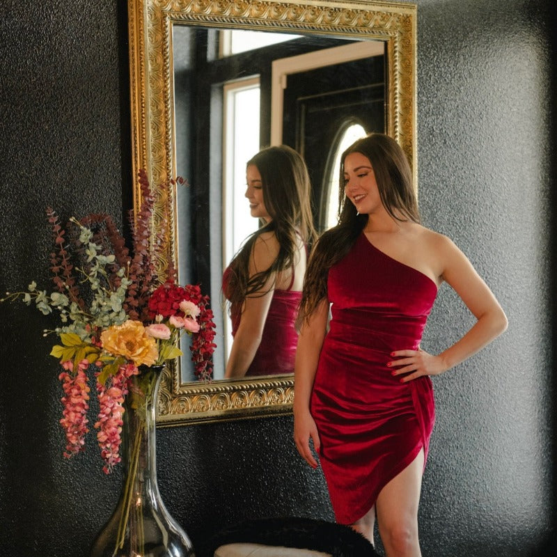 Ultra-soft for all-night comfort in our Rania Velvet Burgundy Dress with a one shoulder that elegantly drapes across and ruches up creating an asymmetrical length. Pair with dressy heels and matching ruby accessories for a goddess look.